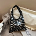 Detail of black faux leather bucket bag featuring silver metal rivets and glossy finish - Black