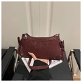 Close-up of wine red leopard print handbag featuring side bows and silver studs - Red