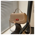 Detailed close-up of cherry embellishment on stylish beige crossbody bag with flap cover - Khaki