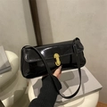 Bolso baguette de charol negro brillante con un elegante cierre metálico dorado en U - Negro