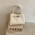 Detailed macro view of the cream lychee grain leather texture and silver turn-lock closure - White without Pendant