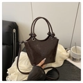Bolso cubo marrón oscuro con elegantes patrones grabados y detalle de asa anudada - café