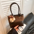 Detail der dunkelbraunen Eimer-Tasche aus Leder und Wildleder mit Teddybär-Anhänger - Kaffee (Mit Anhänger)