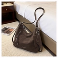 Détail d'un sac hobo marron foncé avec finition mate et mini pochette latérale - café