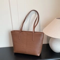 Brown crocodile embossed large tote bag for commuting with dual straps in a cozy home setting - Brown (Without Pendant)