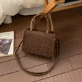Detailed view of leopard print tote bag with brown handles and adjustable strap on a wood floor - Coffee Without Pendant