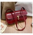 Glossy burgundy patent leather baguette bag with a sleek gold buckle and shoulder strap - Red