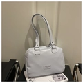 Detail of light blue faux leather handbag with silver logo on a modern black chair - Blue
