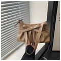 Borsa hobo beige a pieghe con fiocco e borchie a stella, portata a mano per mostrare la forma - Cachi