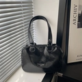 Minimalist black glossy pillow tote bag with dual handles and metal logo detail - Black