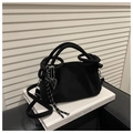Detail of black suede cloud bag with round handle and metallic heart charm on a book - Black (With Pendant)