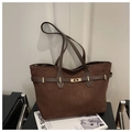 Dettaglio della borsa tote in pelle scamosciata marrone con chiusura dorata e manici - caffè