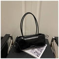 Bolso de hombro baguette negro brillante con asa larga y lazo sobre una silla vintage - Negro