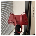 Rode lederen baguette tas met kruisband en metalen gesp in een handbediende display - Rood