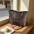 Deep brown large tote bag with embroidery on a wooden window sill in natural sunlight - Brown