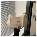 Detalle del bolso media luna crema con lazo metálico y correa de diseño con nudos - Blanco