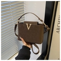 Detailed close-up of dark brown matte leather bag with golden V logo and stylish handle - Coffee
