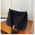 Detalle del bolso bandolera de pana negra con textura acanalada y hebilla dorada - Negro