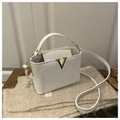Detail of white leather handbag featuring a prominent gold V-shaped metal buckle and strap - White