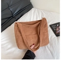 Bolso tote de pana marrón con bolsillo frontal y correa ajustable en entorno real - Marrón