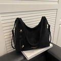 Minimalist black suede tote bag with fringe charm and gold hardware on leather sofa - Black Without Pendant
