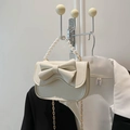 Mini sac beige chic avec nœud, poignée en perles et chaîne dorée sur veste noire - Blanc