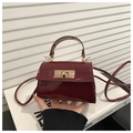 Macro shot of burgundy patent leather mini bag with gold-tone twist lock closure - Glossy Patent Style / Red