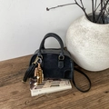Detailansicht der schwarzen Boston Bag mit Holzperlenanhänger und Leder-Struktur - Schwarz Mit Anhänger
