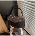 Détail d'un sac bandoulière noir avec motif floral et poignée ronde élégante - Noir (Imprimé Floral Noeud)
