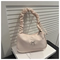 Pale peach pleated hobo bag with silver bow detail and ruffle handle on white books - Pink