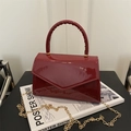 Bolso de mano minimalista en cuero charol burdeos con acabado brillante y cadena dorada - Rojo