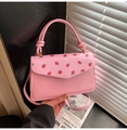 Détail de l'imprimé fraise sur le sac à main rose avec une poignée nouée à la main - Rose (Fraise)