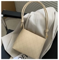 Elegante borsa a secchiello trapuntata crema con tracolla annodata su blazer - Cachi