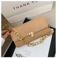 Detalle del bolso bandolera acolchado beige con cadena dorada gruesa y cierre giratorio - Caqui