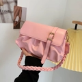 Bolso nube plisado rosa con asa trenzada y hebilla dorada sostenido en la mano - Rosa