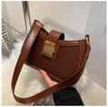 Close-up of brown leather underarm bag with large square gold buckle detail - Brown