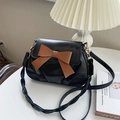 Elegant black pleated leather crossbody bag featuring a large decorative brown bow detail - Black
