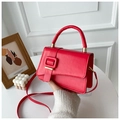 Detail of red leather satchel bag with matte finish and gold-tone metal hardware - Red