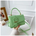 Detail of hand holding a light green mini crossbody bag with a square buckle decoration - Green