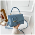 Detail of light blue crossbody bag featuring smooth texture and square buckle accent - Blue