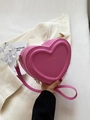 Gros plan du sac à main en forme de cœur en cuir PU rouge rose avec détails dorés - Rose rouge