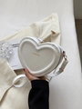 Détail d'un sac cœur en cuir PU blanc avec logo doré et bandoulière assortie élégante - Blanc