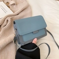 Petit sac bandoulière bleu minimaliste présenté sur un fond en maille douce et chic - Bleu