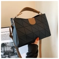 Detail van zwarte handtas met geometrisch reliëf en bruine PU-lederen handvat en riem - Zwart en Khaki