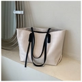 Détail du relief en losange et des poignées noires sur le sac fourre-tout beige épuré - Blanc