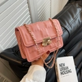 Borsa a tracolla rosa quadrata con trama a griglia e catena dorata tenuta in mano - Rosa