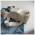 Borsa a tracolla in nylon bianco con ampia tracolla regolabile su sfondo in denim blu - Bianco