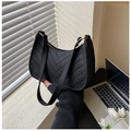Detail of black crescent shoulder bag featuring felt fabric and textured V-quilting - Black