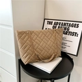 Quilted tote bag in camel PU leather with gold chain strap on a black table - Khaki