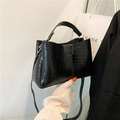 Black crocodile embossed tote bag with top handle and detachable strap in hand - Black